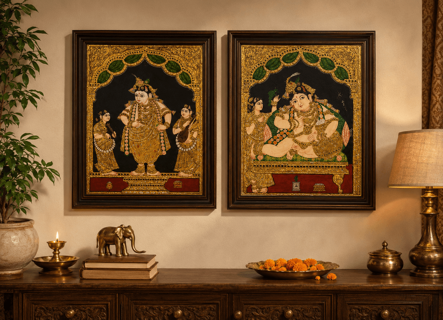 A pair of finished Tanjore paintings custom framed in matching deep walnut mouldings with gold inner liners, displayed above a carved wood sideboard with brass diya, brass elephant figurine, marigold offerings, and brass lamp in a Central NJ family home altar arrangement
