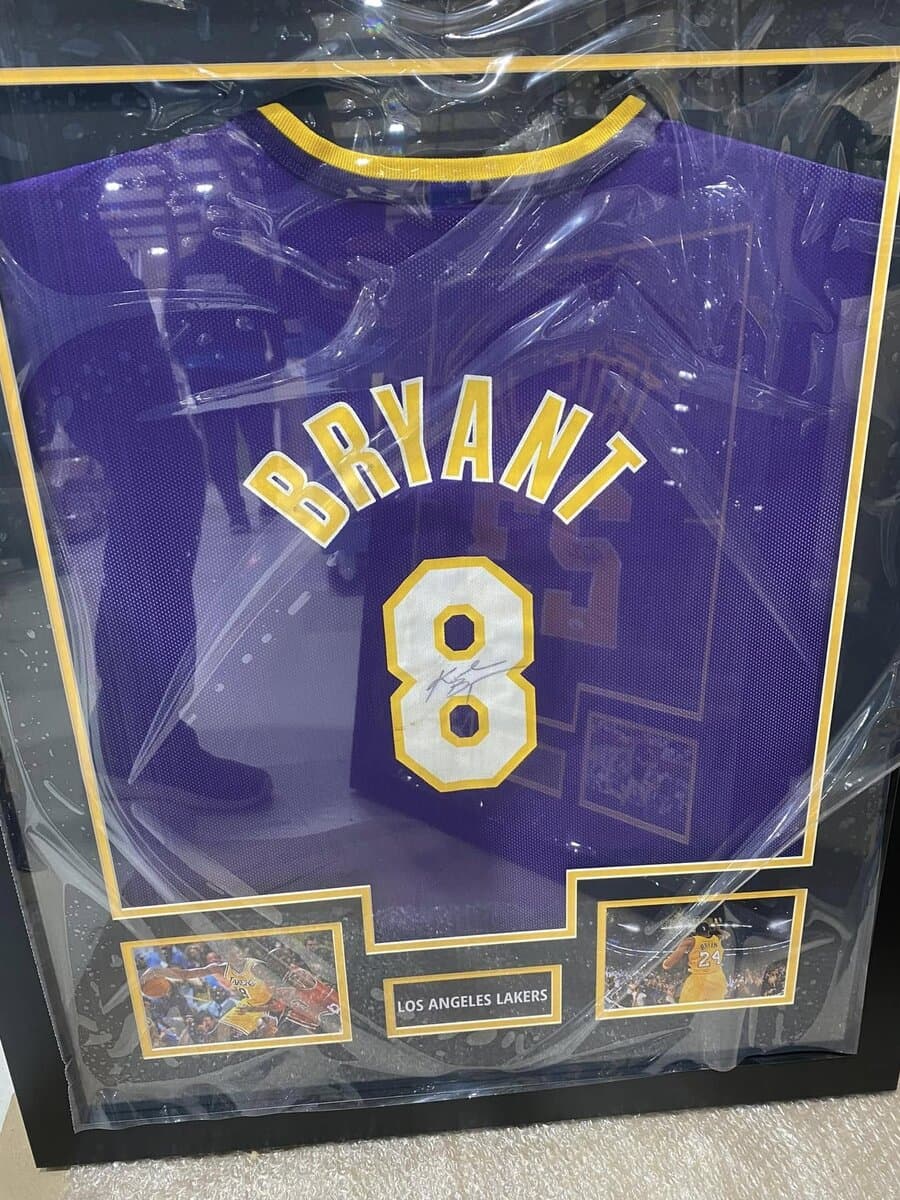 Autographed Kobe Bryant Lakers jersey framed in deep shadow box with gold accent matting and clear framer's grade acrylic