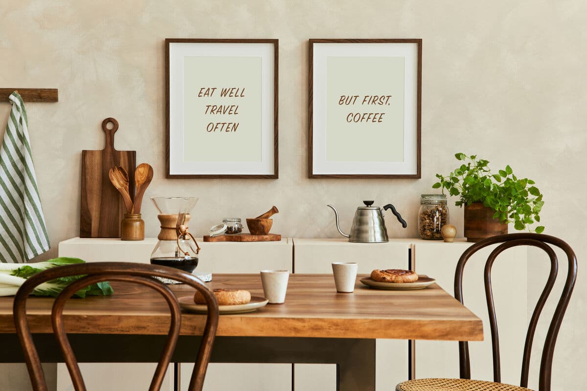 Two Mahogany Picture frames with coffee-themed prints displayed above kitchen table creating warm inviting breakfast nook atmosphere