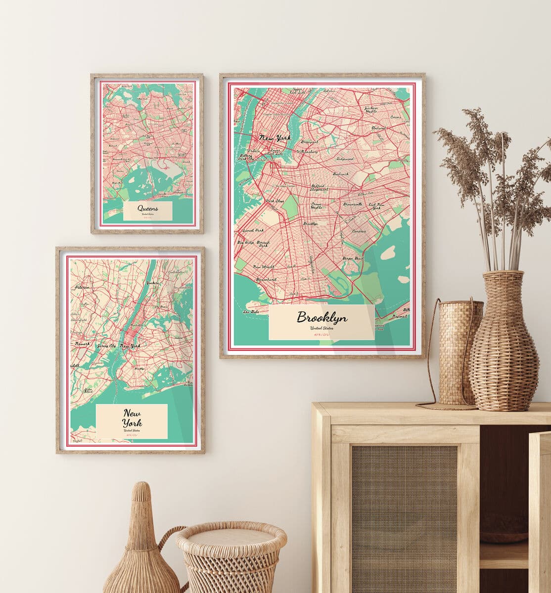 Three Natural Wood frames with vintage map prints labeled Brooklyn New York and Queens hang above wooden cabinet with wicker decor and dried plants