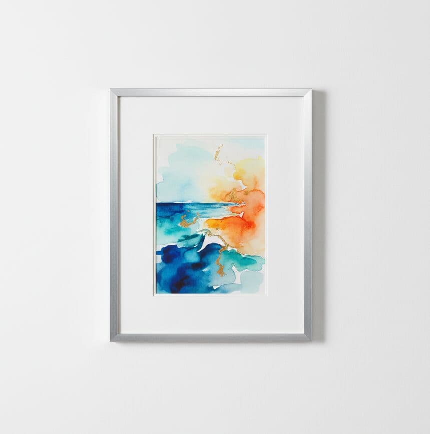 Silver Picture Frame displaying vibrant abstract ocean watercolor with blue and orange tones showcasing sleek metallic finish on neutral wall