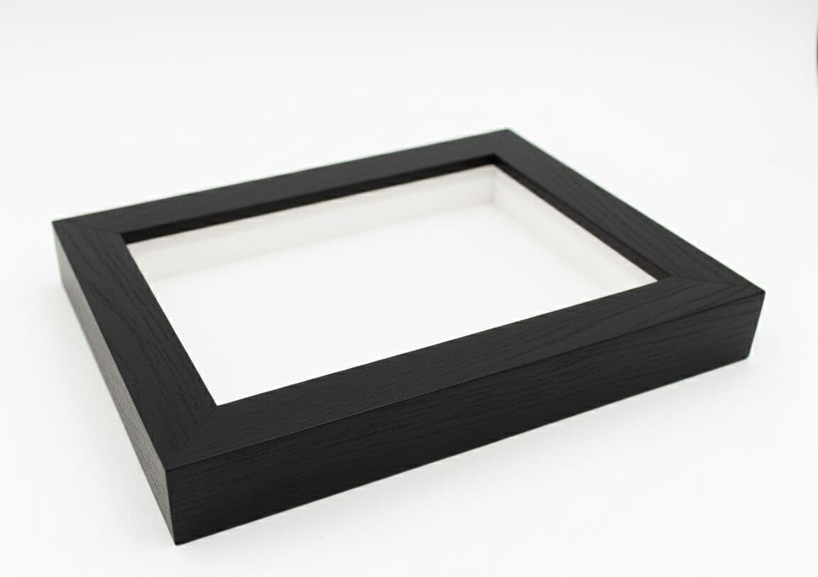 Empty slim matte black shadowbox picture frame on white background showcasing ultra-slim 0.75 inch contemporary moulding profile with 1 inch interior depth channel and refined black wood grain finish a natural fit for custom dimensional object display frames and modern minimalist shadowbox applications