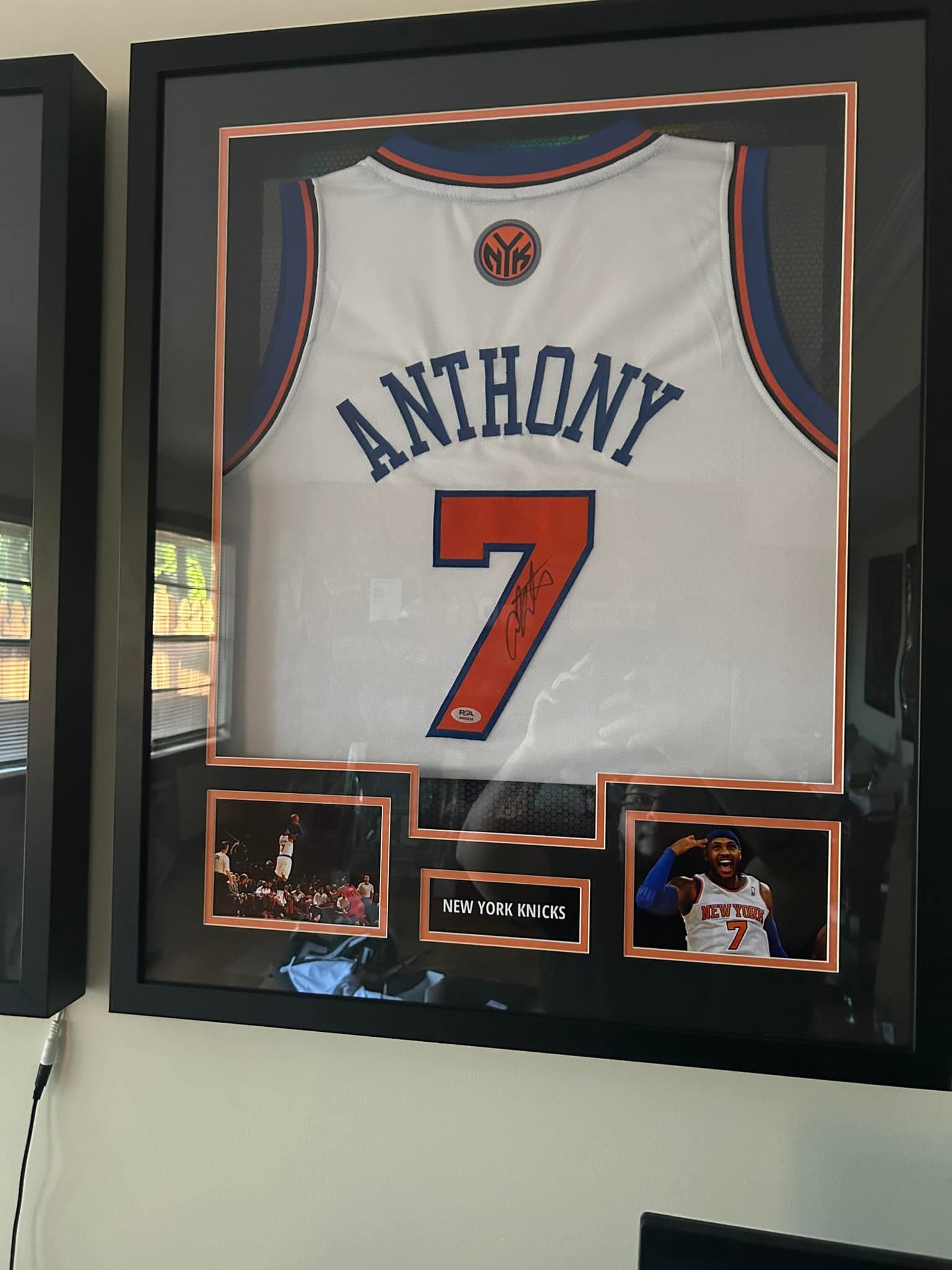 Signed Carmelo Anthony #7 New York Knicks white home jersey framed in a black moulding with orange and blue double mat, twin action shots, and 'New York Knicks' nameplate