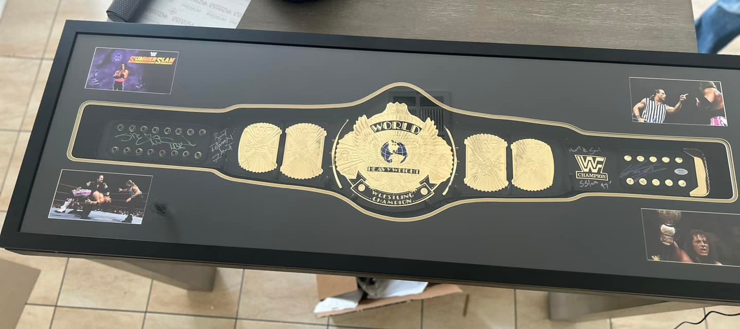 Multi-signed WWF Hasbro World Wrestling Champion belt framed in a wide black shadow box with four corner action stills (SummerSlam, referee, in-ring shots)