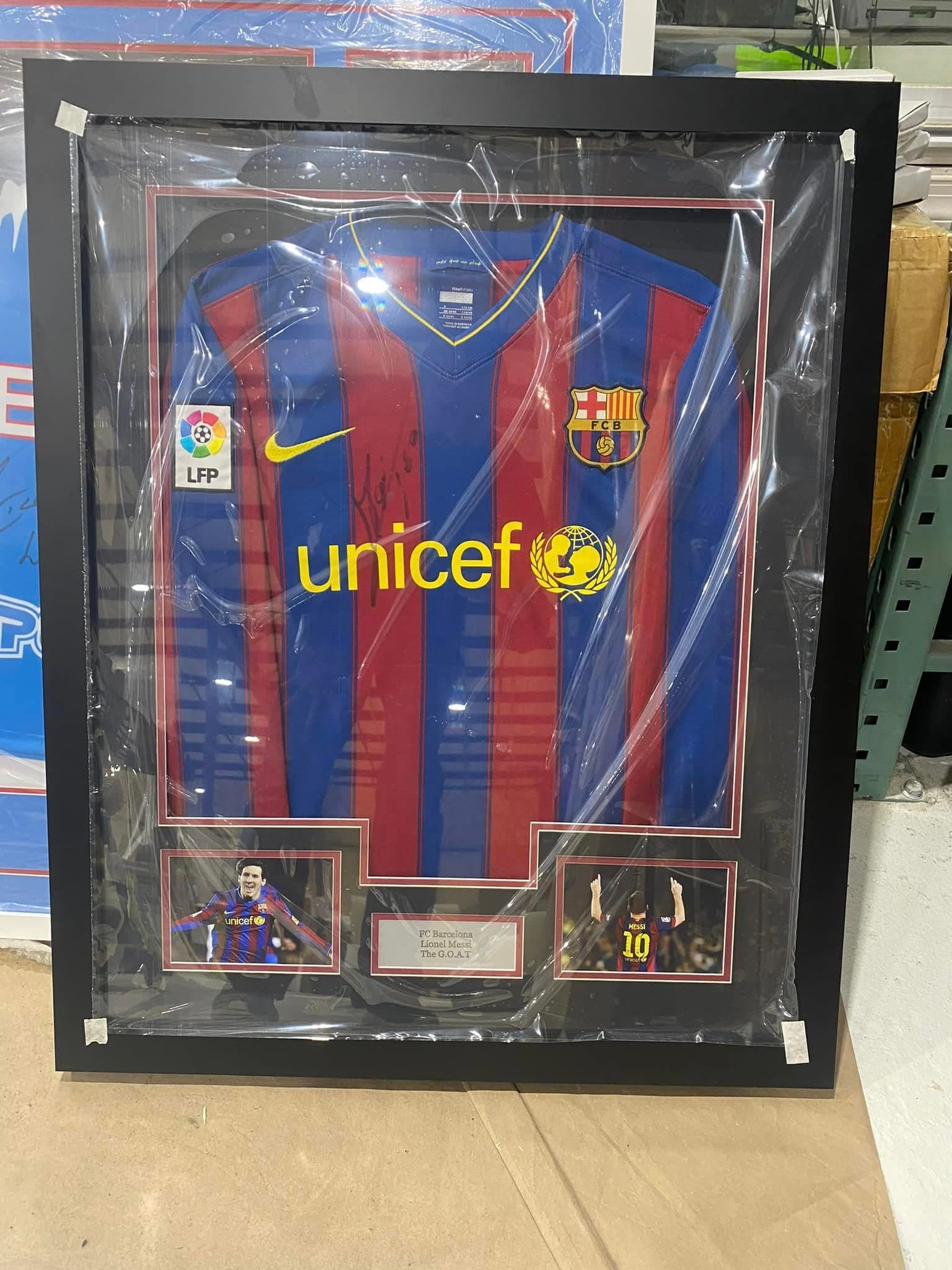 Signed Lionel Messi FC Barcelona 2010-11 home jersey with UNICEF sponsor and LFP / FCB crests, framed in a black shadow box with twin Messi action shots and 'FC Barcelona / Lionel Messi / The G.O.A.T' nameplate
