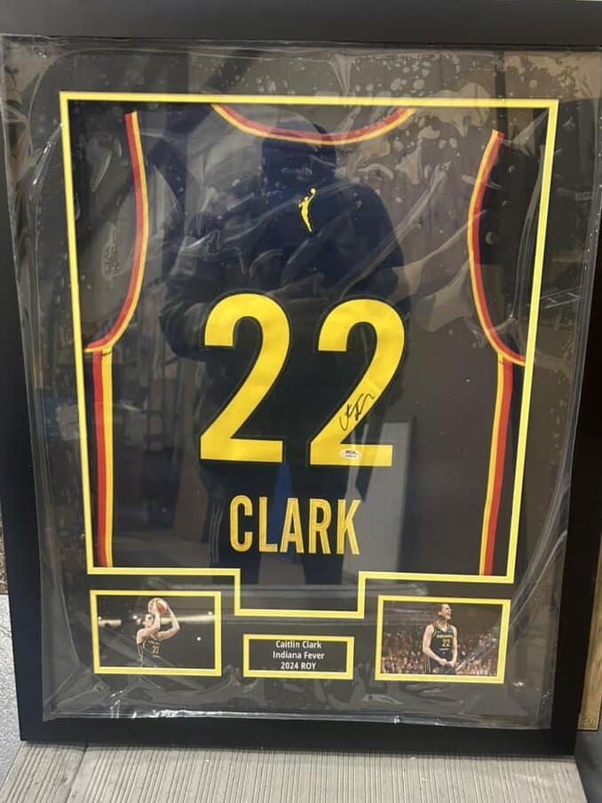 Sports memorabilia shadow box framing example: autographed Caitlin Clark Indiana Fever jersey mounted with archival materials and Rookie nameplate