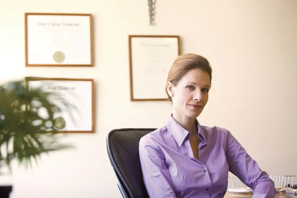 woman showcasing her framed degrees